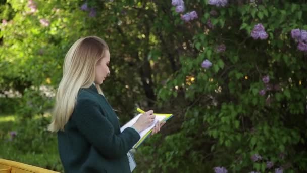 Όμορφη Μαθήτρια Ντυμένη Σκούρο Σμαραγδένιο Πράσινο Παλτό Γράφει Σημειωματάριο — Αρχείο Βίντεο