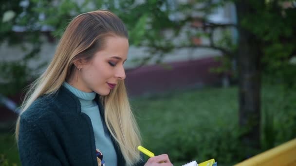 Student Dziewczyna Ubrana Ciemny Szmaragdowy Zielony Płaszcz Jest Pisanie Notatniku — Wideo stockowe