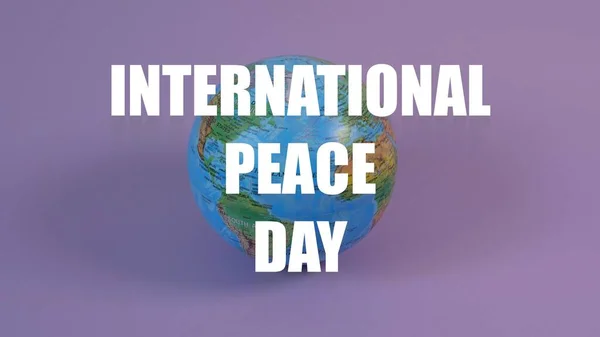International peace day inscription written on the Earth globe model. Violet background.