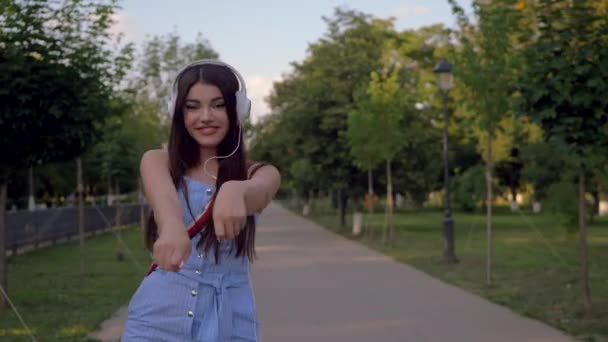 Glada Unga Latinska Kvinnan Sätter Sig Sina Vita Hörlurar Och — Stockvideo