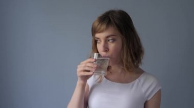 Kadın ilaç içiyor ve suda eriyor. Köpüklü su içen kadın. 