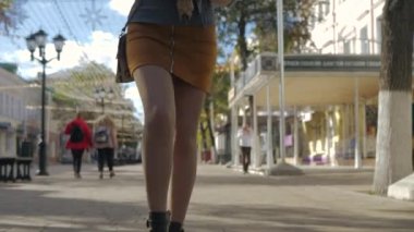 Büyüleyici kadın elinde bir buket çiçekle şafak vakti yürüyor. Şık sokak modası. 