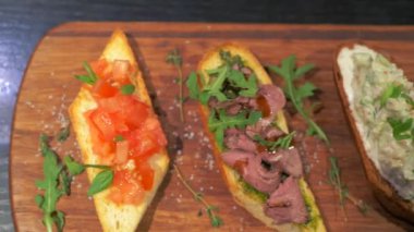Taze sandviç ve buğday sandviçi. Ringa balıklı Rus sandviçi, somon balığı, tahta tahtada salata. Adım adım. Bardaki yemek. Sandviç makinası.