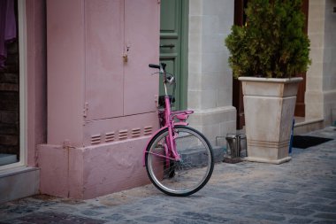 Avrupa 'nın kaldırım taşı caddesinde pembe bir bisiklet park edilmiş..