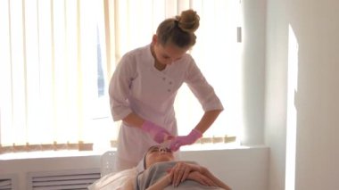 Güzellik uzmanı müşterinin yüzündeki maskeyi çıkarır. Cilt bakımı kavramı. 