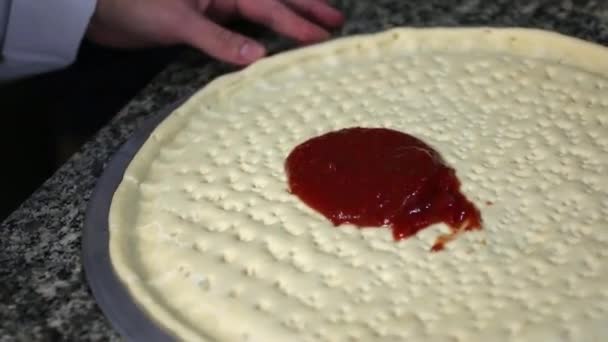 シェフはケーキの上でソースをスミア ピザ用の生地の準備 — ストック動画
