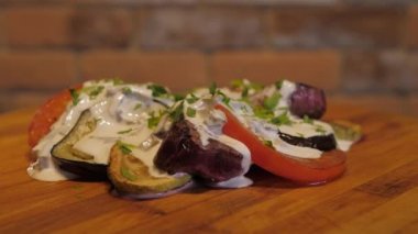 İştah açıcı sığır filetosu ızgara sebze ve krema soslu mantar ve ahşap bir masada otlar. Çanak daire şeklinde döner. Arka planda kırmızı tuğla duvar.