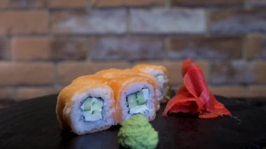 Filadelfia, kırmızı tuğla duvarın arkasındaki siyah bir stantta dönüyor. Bulaşık, wasabi ve zencefilli Japon yemeği. Bir Asya restoranı için etkileşimli bir menü ögesi.