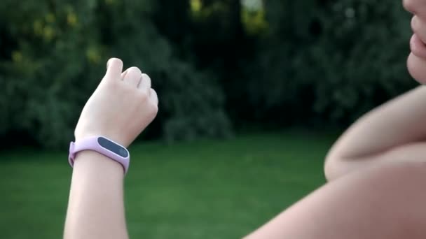 Meisje Met Lang Haar Kijkt Naar Fitness Armband — Stockvideo
