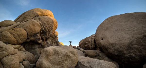 Small man next to large rocks — Stock Photo, Image