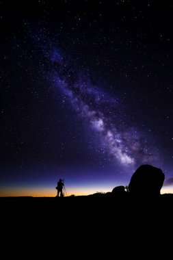 Astro Photographer in a Desert Landscape with view of Milky Way Galaxy clipart