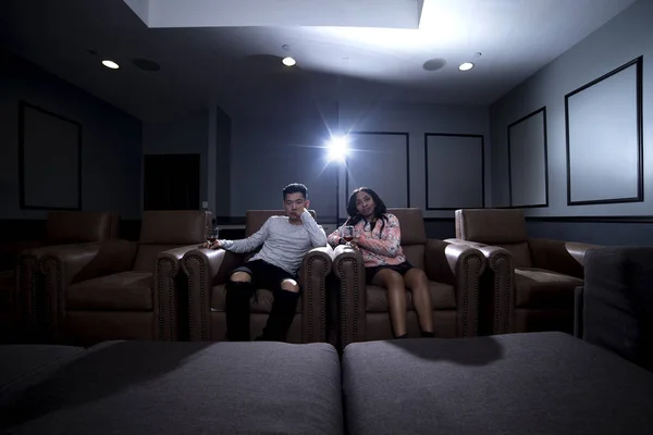 Coppia interrazziale guardando un film in un sistema Home Theater — Foto Stock