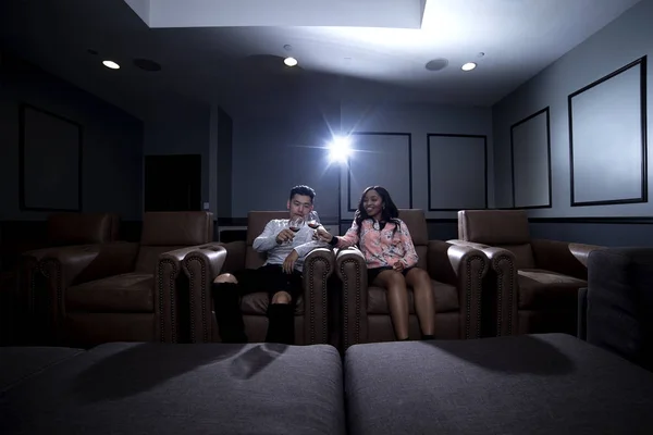 Couple Interracial Regarder un film dans un système de cinéma maison — Photo