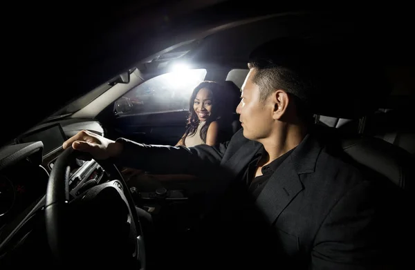 亚裔男子开车与黑人女性约会的汽车 他们看起来像是去夜总会夜生活 图像描绘了异族关系和生活方式 — 图库照片
