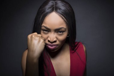 Kızgın ifadeleri ile karanlık bir arka plan üzerinde siyah kadın modeli.