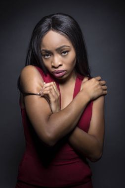 Üzgün ve depresyonda ifadeleri ile karanlık bir arka plan üzerinde siyah kadın modeli.