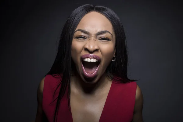 Black female model on a dark background with angry expressions.