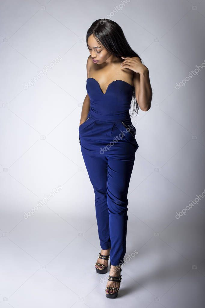Sexy black female fashion model wearing apparel with blue pants.  The outfit is modern style for spring or summer clothing collection. The image depicts trends in womenswear