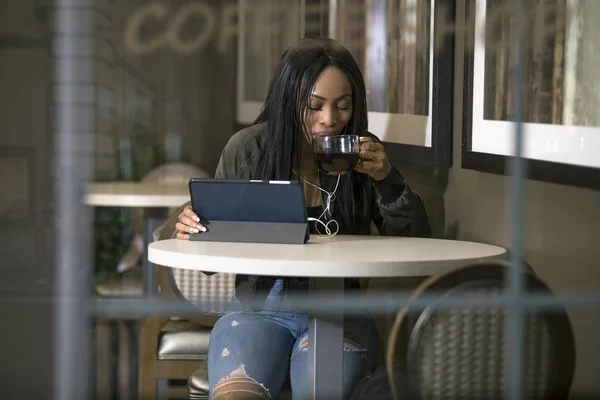 헤드폰을 Wifi 스트리밍 커피숍에서 태블릿에 비디오를 여성의 인터넷 그녀는 앉아서 — 스톡 사진
