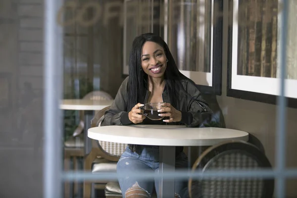 コーヒー ショップや歩道のカフェでコーヒーを飲んで黒人女性を表示するウィンドウ ブレークまたは学生起業家実業家が辛抱強く待っていると独立に見える — ストック写真
