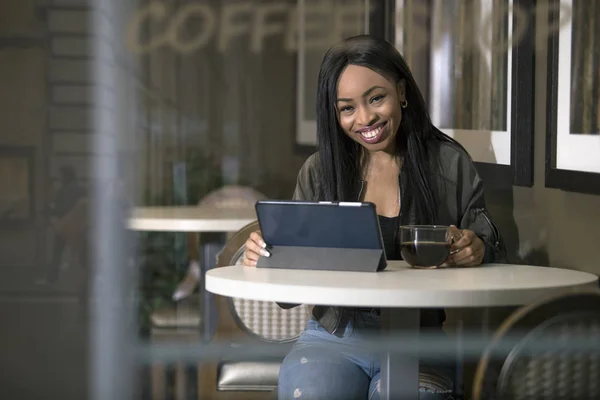 Vista Janela Uma Mulher Negra Usando Tablet Conectado Internet Coffeeshop — Fotografia de Stock