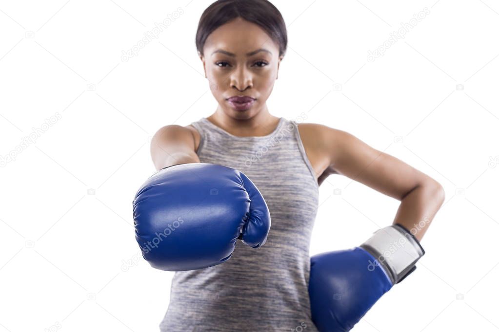 Black female on a white background wearing boxing gloves pointing forward.  Part of image set for gritty woman series.