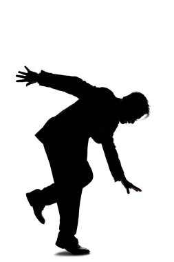 Silhouette of a backlit model posing as a businessman on a white background.  He is balancing or slipping and falling due to an accident clipart