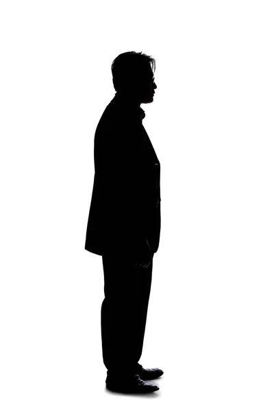 一个背光模特在白色背景下装扮成商人的轮廓 他站着耐心地等待着 — 图库照片