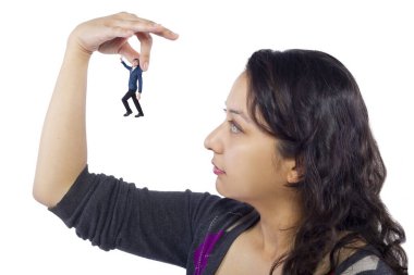 Gigantic woman holding a tiny little businessman as a metaphor for loss of self-confidence.  The man is feeling vulnerable and defenseless isolated on a white background clipart