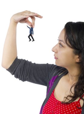 Gigantic woman holding a tiny little businessman as a metaphor for loss of self-confidence.  The man is feeling vulnerable and defenseless isolated on a white background clipart