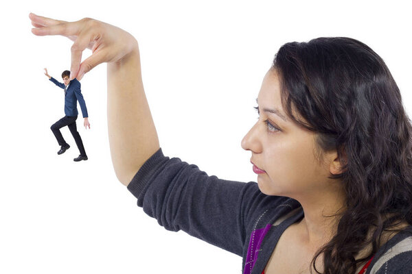 Гигантская женщина держит крошечного бизнесмена в качестве метафоры потери уверенности в себе. Человек чувствует себя уязвимым и беззащитным изолированным на белом фоне
