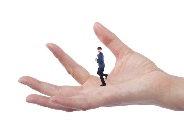 Гигантская женщина держит крошечного бизнесмена в качестве метафоры потери уверенности в себе. Человек чувствует себя уязвимым и беззащитным изолированным на белом фоне
