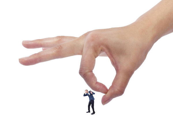 Гигантская женщина держит крошечного бизнесмена в качестве метафоры потери уверенности в себе. Человек чувствует себя уязвимым и беззащитным изолированным на белом фоне
