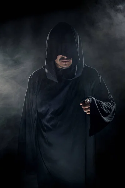 穿着深色长袍的男人 看起来像烟雾弥漫的背景下的邪教领袖 他看起来像个可怕的坏人 — 图库照片