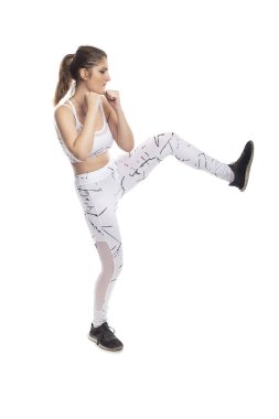 Kadın tekme atarken dengede durarak çekirdek gücünü gösteriyor. Kickboks, mma dövüş sporu ya da kardiyo egzersizleri için antrenman yapıyor..