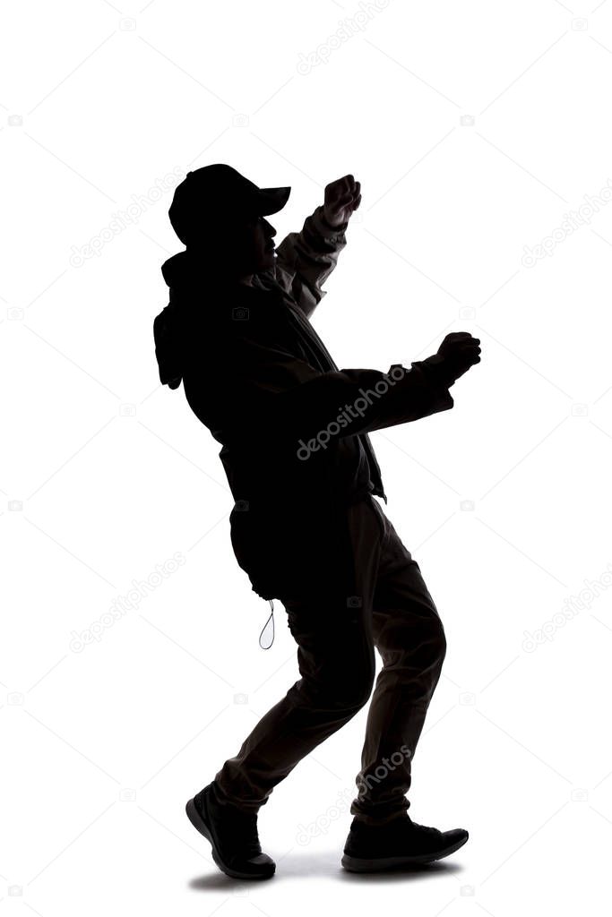 Silhouette of a male hiker or explorer isolated on a white background wearing a hat and clothes for trekking. He is falling or off balance