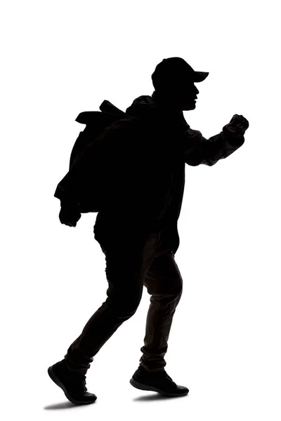 旅行者やハイカーのトレッキングのように見えるバックパックを着て男のシルエット 彼は歩くかハイキングしている — ストック写真
