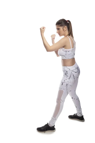 Zdolna Młoda Kobieta Pozycji Bojowej Nosząca Sportowe Stroje Ćwicząca Uderzając — Zdjęcie stockowe