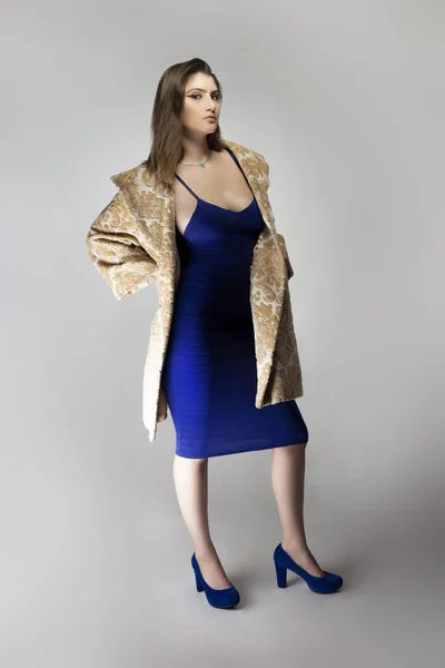 ベージュのブロケードウールやコットンコートを身に着けている女性ファッションモデルとスタジオカタログスタイルで青セクシーなドレス 春や秋の傾向を描く — ストック写真