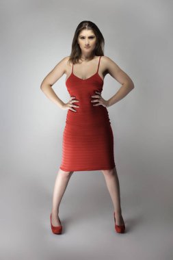 Beyaz bir kadın mankenin şarap ya da gül kırmızısı yaz elbisesi giyerken çekilmiş katalog tarzı bir fotoğraf. Moda tarzını göstermek için poz veriyor.