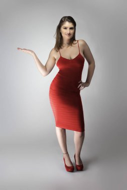 Beyaz bir kadın mankenin şarap ya da gül kırmızısı yaz elbisesi giyerken çekilmiş katalog tarzı bir fotoğraf. Moda tarzını göstermek için poz veriyor.