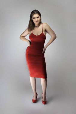 Beyaz bir kadın mankenin şarap ya da gül kırmızısı yaz elbisesi giyerken çekilmiş katalog tarzı bir fotoğraf. Moda tarzını göstermek için poz veriyor.