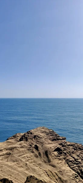 Вертикальний Краєвид Блакитного Океану Кам Янистої Запорошеної Скелі Денний Час — стокове фото