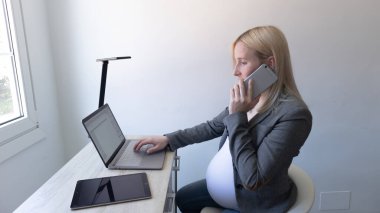 Sarışın kız telefonla arıyor ve çalışıyor.