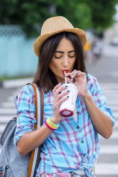 Gadis di kota mengenakan kemeja minum koktail jus segar, menikmati ransel brunette, kecokelatan, sensual make-up, konsep rekreasi, perjalanan, gaya hidup. Hari musim panas . — Stok Foto