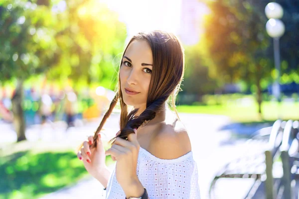 Portret van een prachtige brunette in witte blouse in de zomer, in de het park, met lange haren. Geniet van uw vakantie, jeugdconcept, lifestyle. Genieten van de rest, houden haar lachen. — Stockfoto