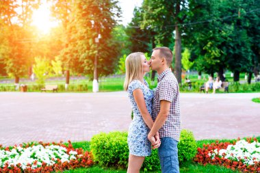 Genç çift, birbirlerinin ellerini öpmek holding park şeritte duran bir bildirim aşk, nazik, sarıl, kavram aile, mutlu bir evlilik. Şehirde bir yaşam tarzı. Açık havada.