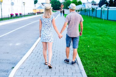 Erkek ve kadın taş döşeme tutuşup, yaz City, olay genç aile, yeni evliler karmaşık ilişkileri kavramı. Romantik bir yaşam tarzı. Açık havada.