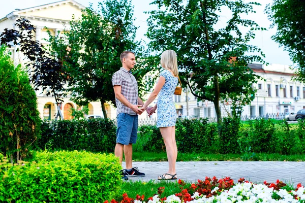 Młoda para w parku wstążki gospodarstwa nawzajem ręce, wyznanie miłości, delikatne przytulić, pojęcie rodziny, szczęśliwe małżeństwo. Styl życia w mieście. Na zewnątrz. — Zdjęcie stockowe