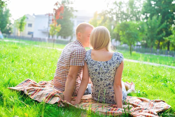 Jovem casal homem e mulher sentados em um banco abraçando na fita do parque, declaração de amor, abraço gentil, família conceito evento, casamento feliz. Estilo de vida na cidade. Ao ar livre . — Fotografia de Stock